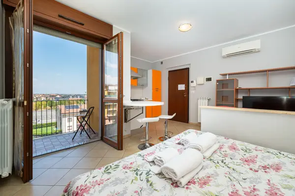Turin Airport apt F — letto matrimoniale con porta-finestra sul balcone e vista