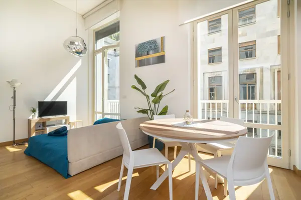 Loft Frola — soggiorno con grandi finestre sulla via